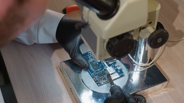 Researcher examining circuit board in a lab
