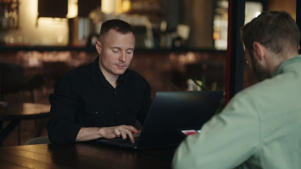 freelancers-working-in-cafe-men-professionals-in-it-and-web-design-sitting-at-table-wi-SBI-350818490-1